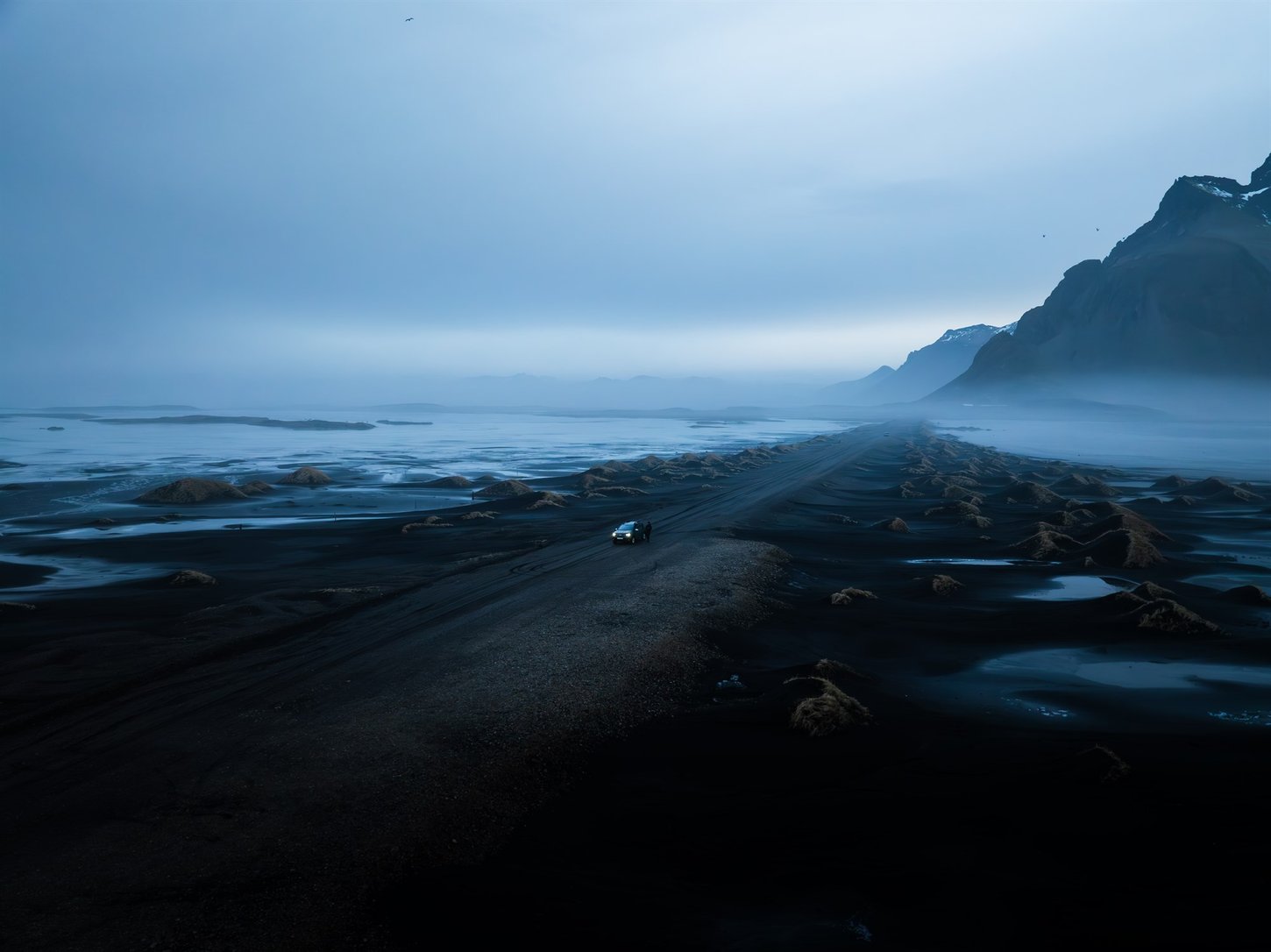 Car driving on black sand in Iceland