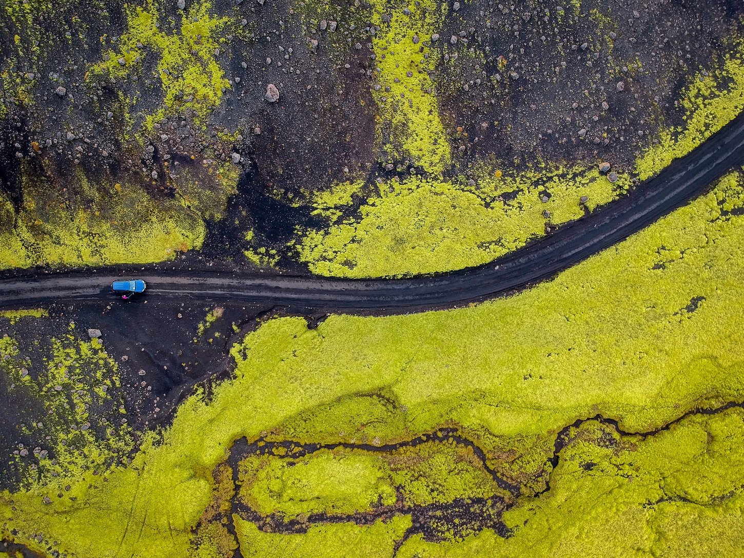 Aerial view of a blue car on the F-roads in Iceland.