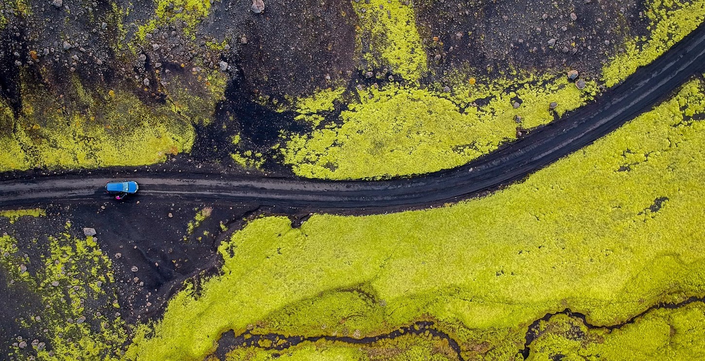 Aerial view of a blue car on the F-roads in Iceland.