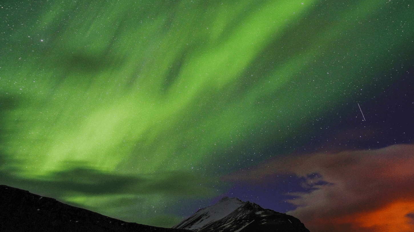  Green Northern Lights across a starry sky in Reykjavík.