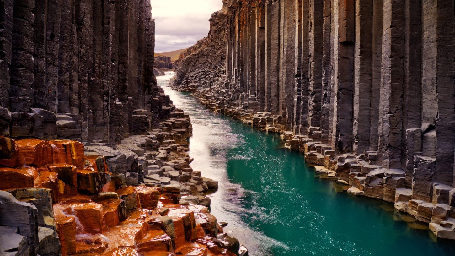 Turquoise river and basalt columns of Studlagil Canyon, Iceland.