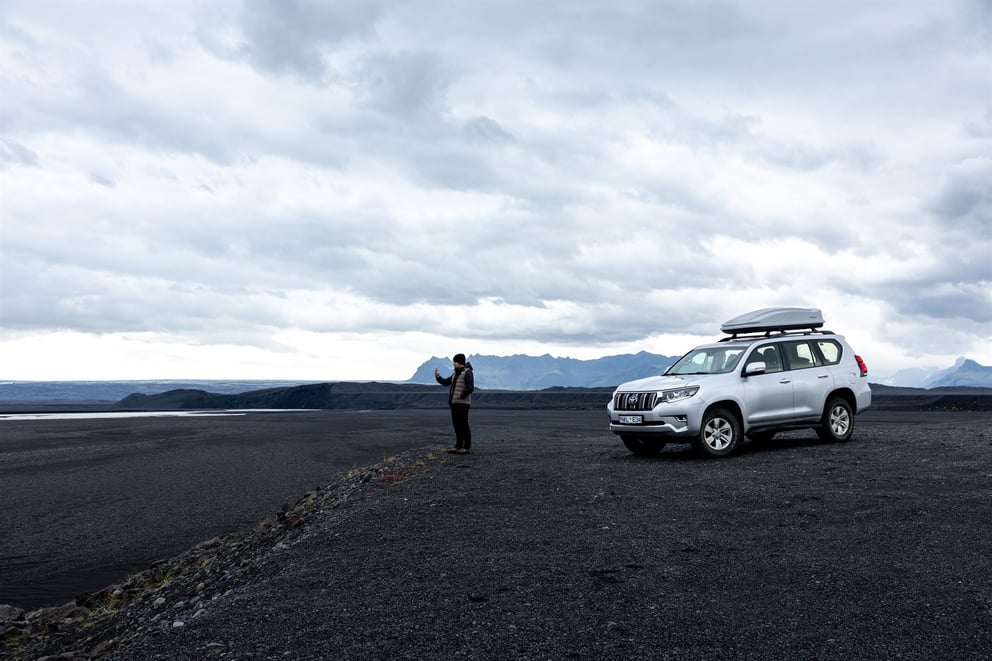 Image of a person standing outside of a 4x4 vehicle in iceland