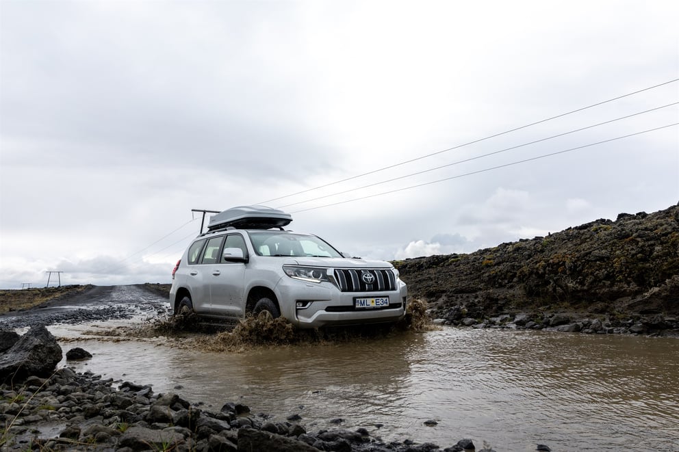 Image of a 4x4 rental in Iceland, Land Cruiser, driving through water