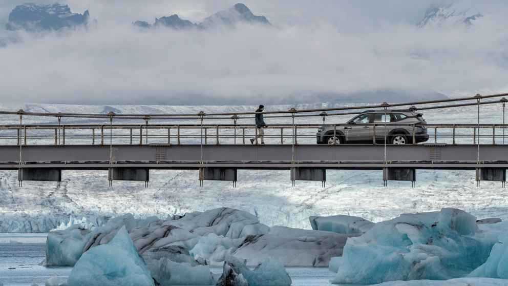 Icelandic glacial landscape with bridge and car.