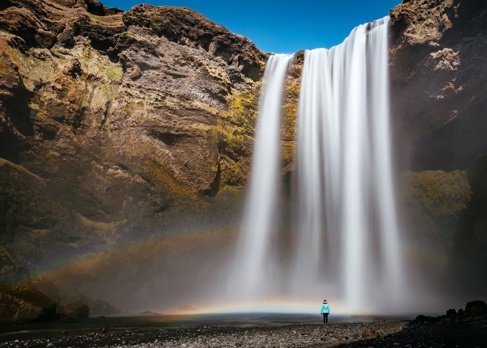 Rainbows appearing at the base of Skogafoss waterfall in Iceland. 