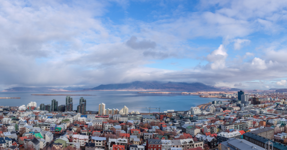 Aerial shot over Reykjavik buildings into the bay.