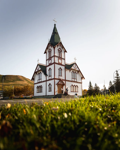 Tall, white Husavikurkirkja in northern Iceland.