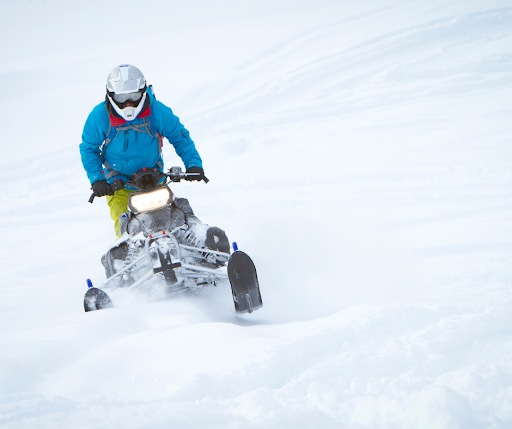 Person snowmobiling through the snow