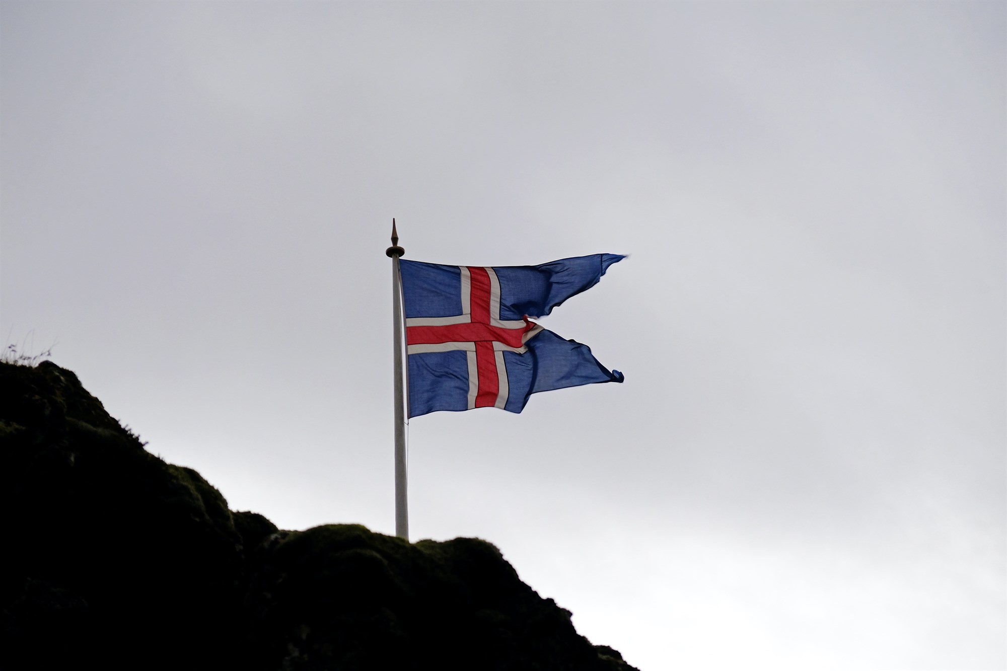 Icelandic flag on a rocky mountain.
