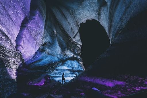 Person standing inside an ice cave in Iceland at night