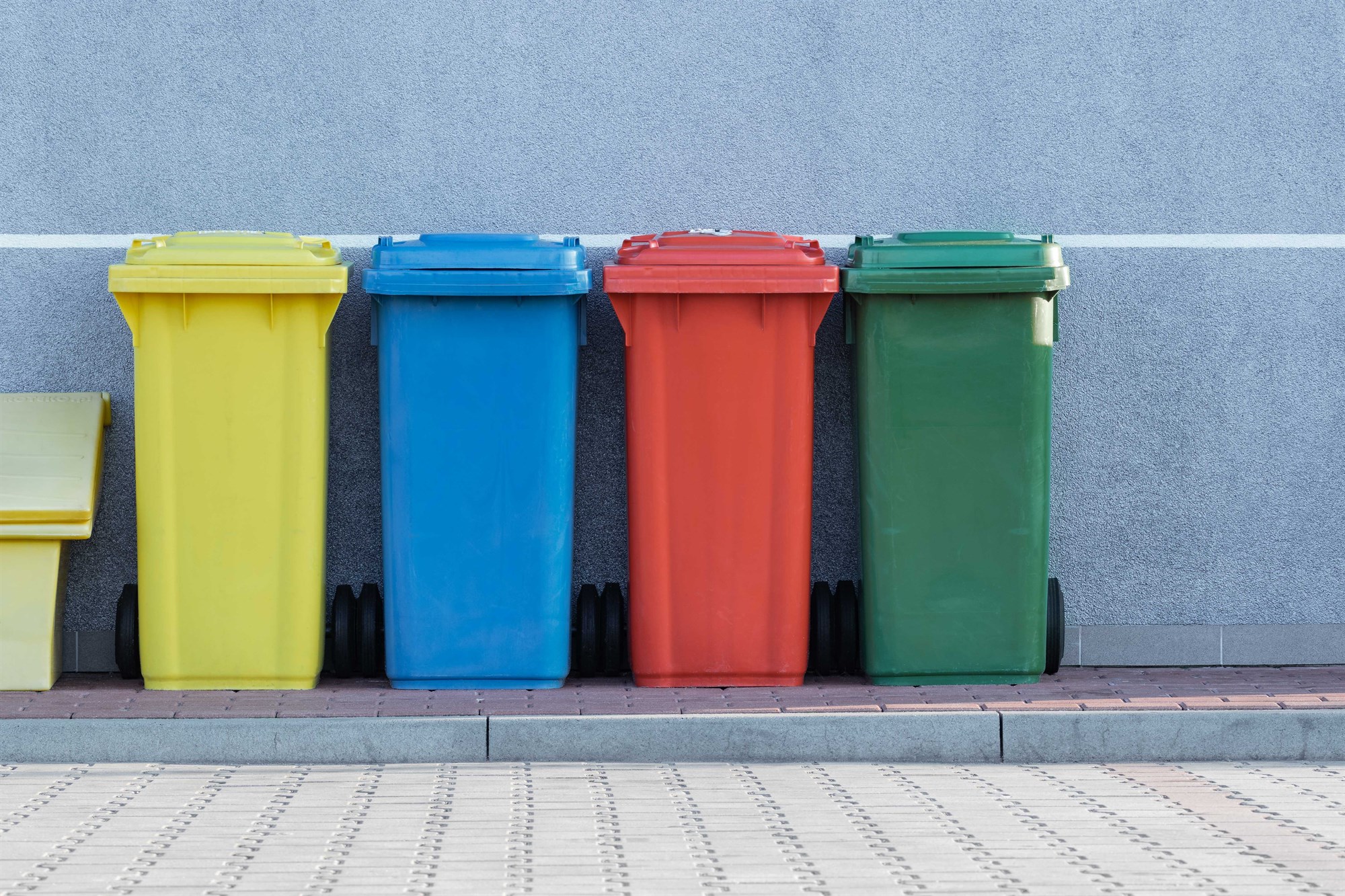 A row of colourful recycling bins.